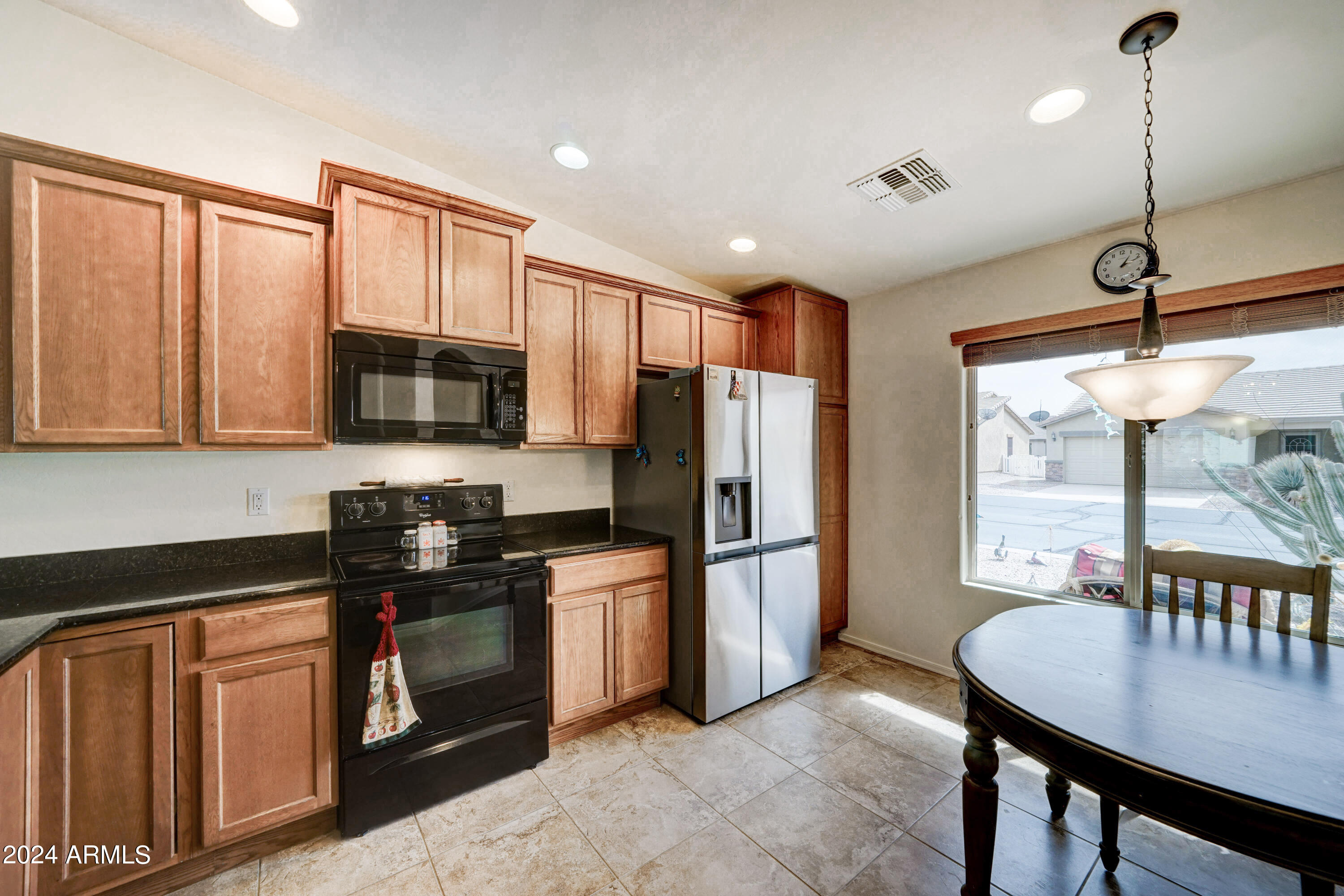 2101 South Meridian Road, Unit 157 Apache Junction, AZ 85120 - Photo 5 of 51 a kitchen with stainless steel appliances granite countertop a refrigerator a stove top oven a sink a dining table and chairs