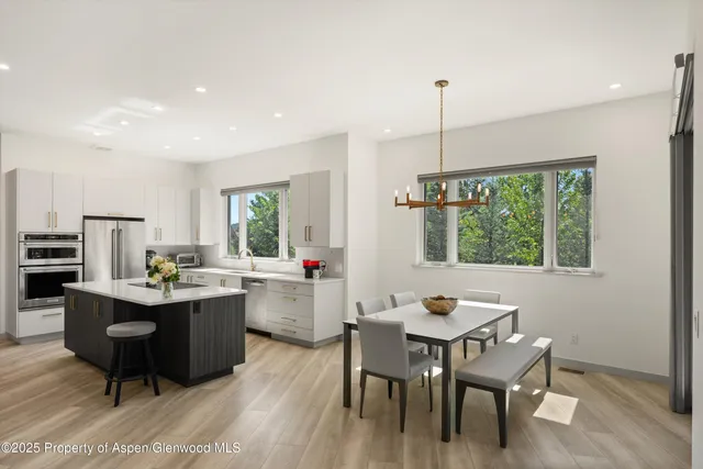 a view of a dining room with furniture large windows and wooden floor