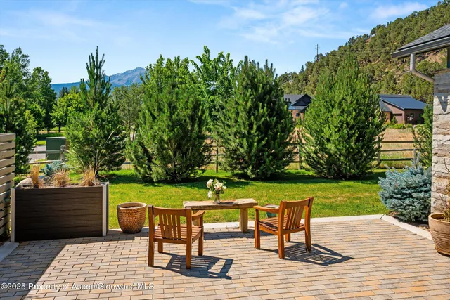 a view of a house with a big yard and large trees