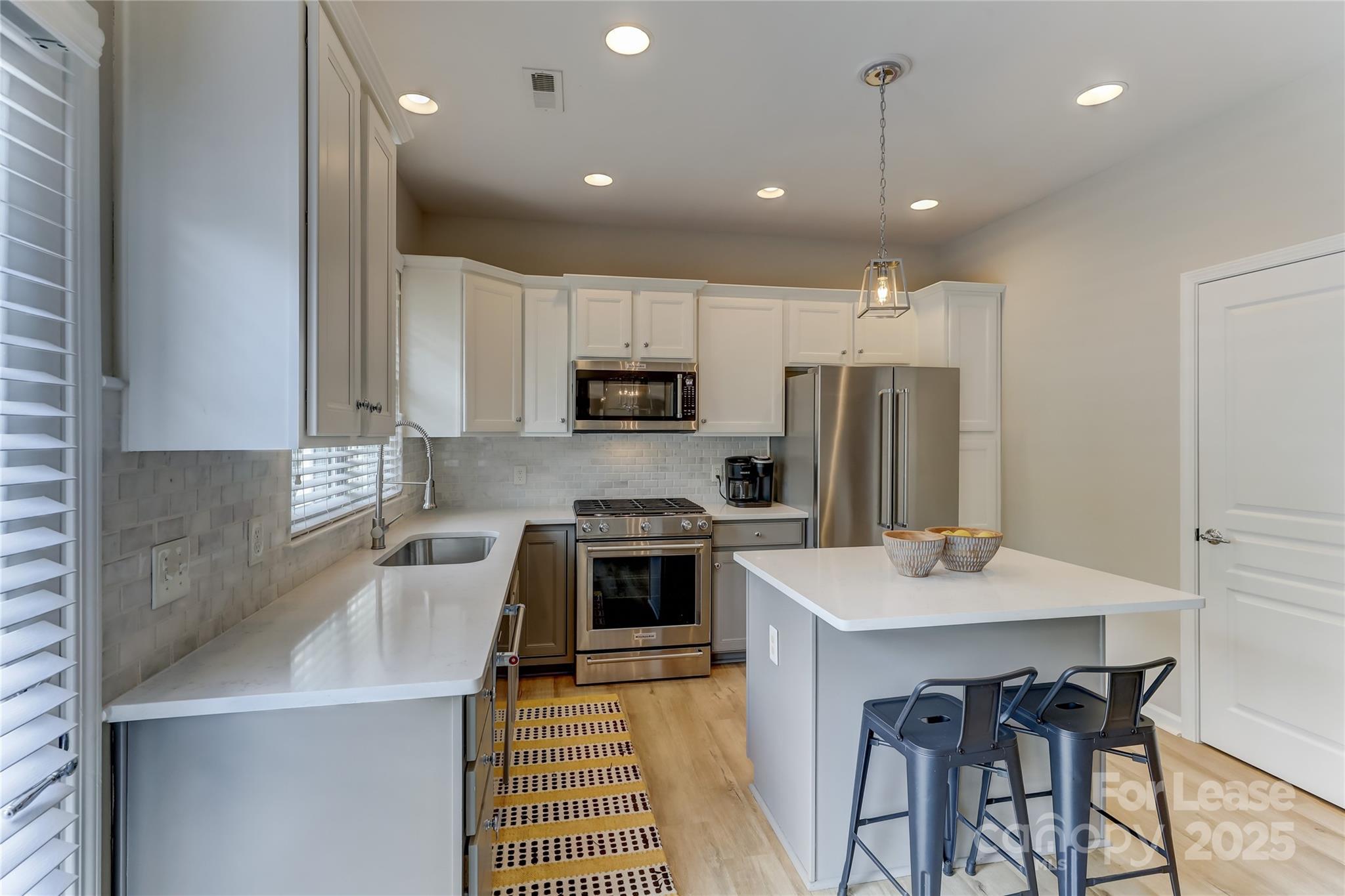 1132 Drayton Court Fort Mill, SC 29708 - Photo 15 of 48 a kitchen with a sink a stove a refrigerator and white cabinets with wooden floor