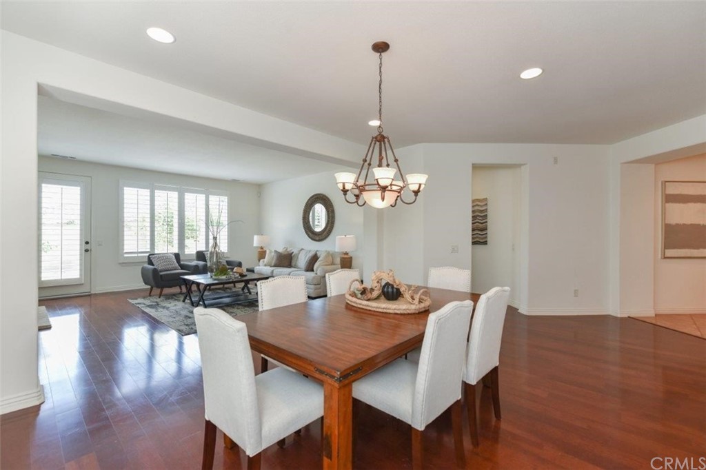 17 Stonegate Irvine, CA 92602 - Photo 14 of 72 a view of a dining room and livingroom view with wooden floor a chandelier a wooden table and chairs
