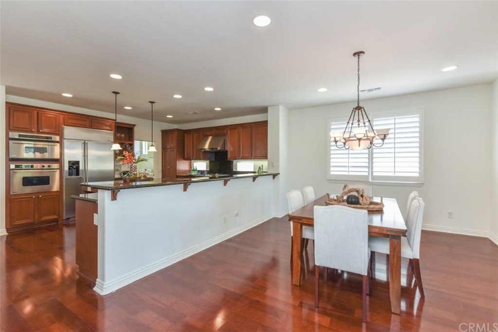 17 Stonegate Irvine, CA 92602 - Photo 18 of 72 a kitchen with stainless steel appliances wooden floor dining table and chairs