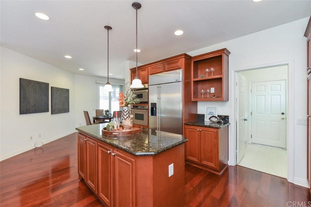 17 Stonegate Irvine, CA 92602 - Photo 21 of 72 a kitchen with stainless steel appliances granite countertop a sink a refrigerator and a wooden floor