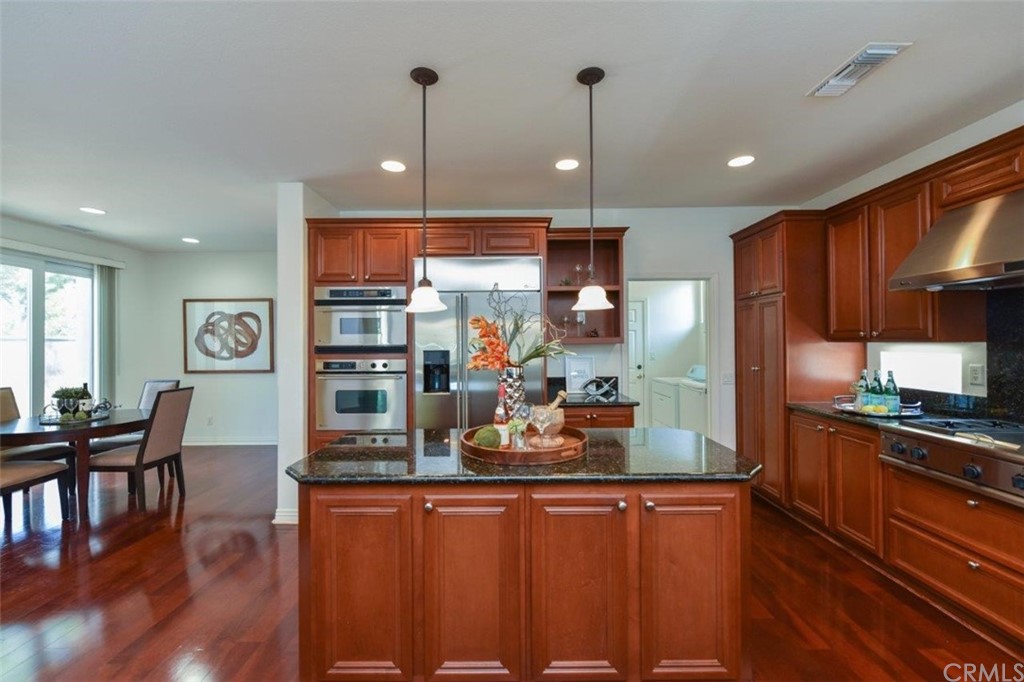 17 Stonegate Irvine, CA 92602 - Photo 27 of 72 a kitchen with stainless steel appliances granite countertop a refrigerator a sink dishwasher a stove and white cabinets with wooden floor
