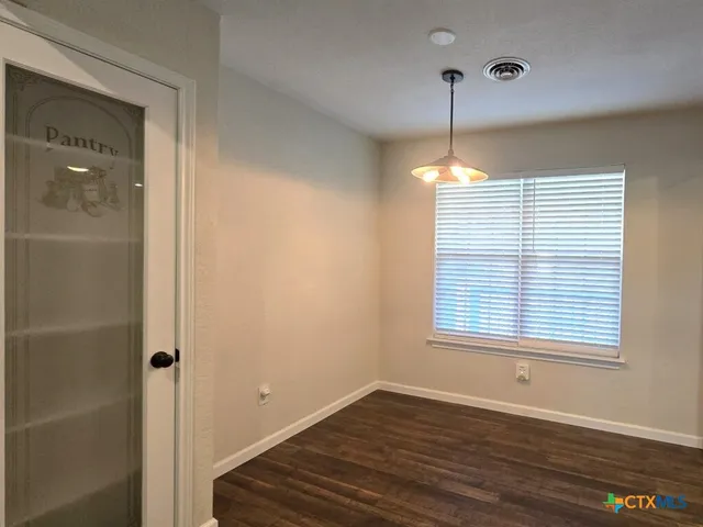 a view of a room with wooden floor and windows