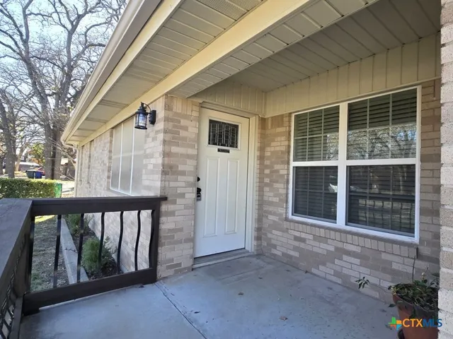 a view of backyard with large trees and plants