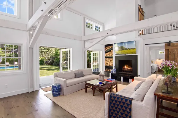 a living room with furniture a fireplace a rug and a window