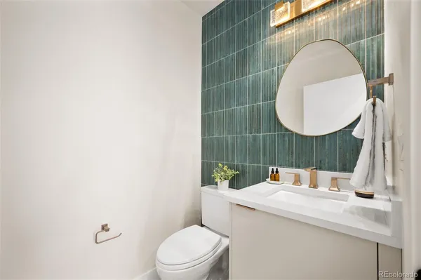 a bathroom with a sink mirror vanity and toilet
