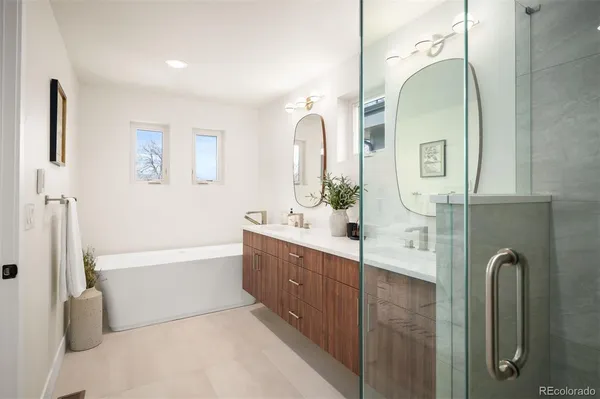 a bathroom with a double vanity sink mirror and bathtub