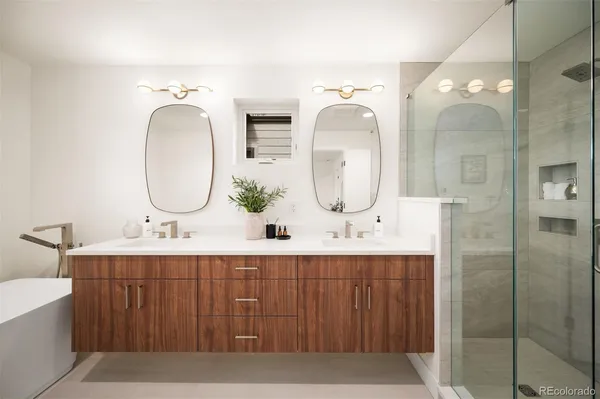 a bathroom with a double vanity sink mirror and shower