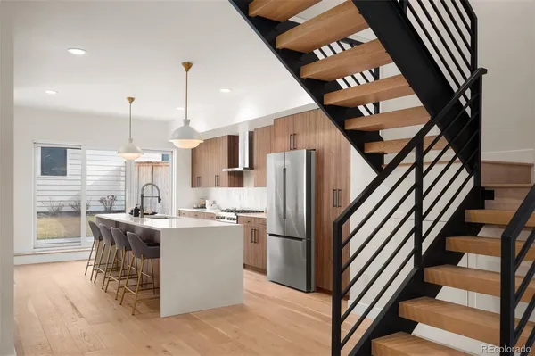 a kitchen with stainless steel appliances granite countertop a refrigerator and a stove top oven