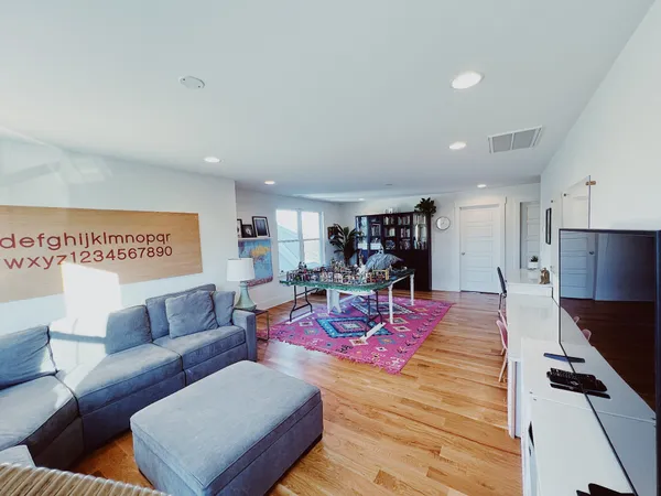 a view of a living room and a dining room with furniture and wooden floor