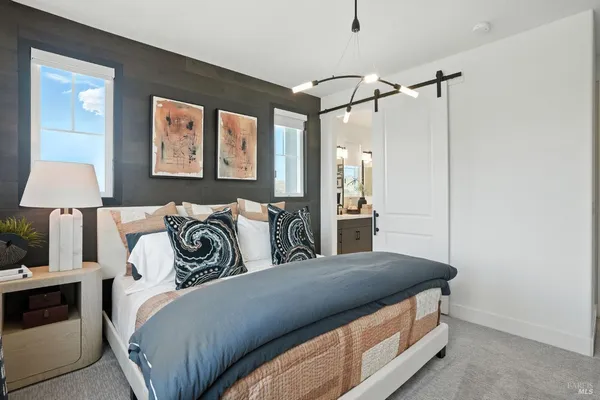 a spacious bedroom with a bed and a lamp