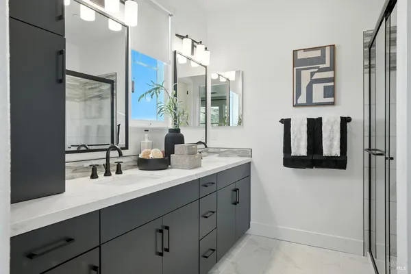 a bathroom with double sink and two mirror