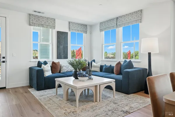 a living room with furniture wooden floor and a window