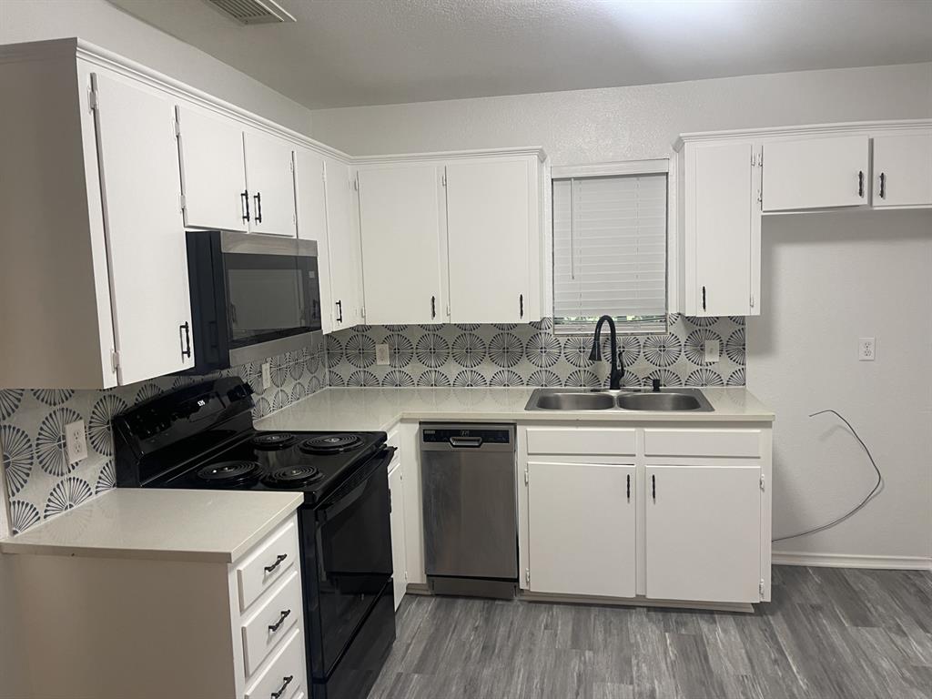 411 Smith Street Bonham, TX 75418 - Photo 4 of 22 Kitchen featuring light countertops, white cabinets, and backsplash