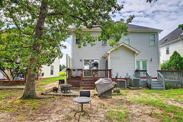 a view of a chair and table in backyard of the house