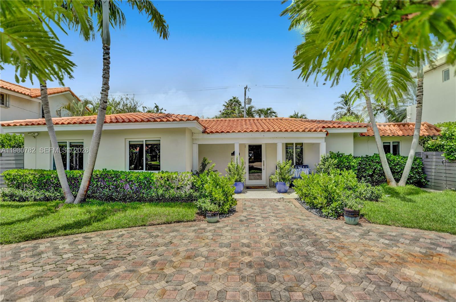 462 Glenridge Road Key Biscayne, FL 33149 - Photo 2 of 32 a front view of a house with a garden