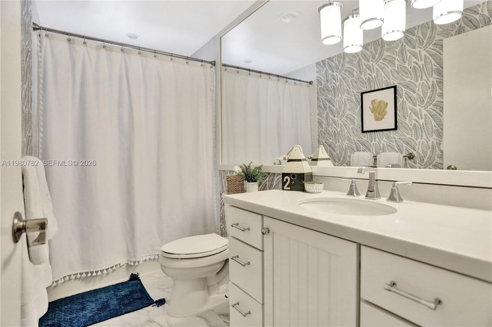 462 Glenridge Road Key Biscayne, FL 33149 - Photo 23 of 32 a bathroom with a sink a toilet and shower curtain