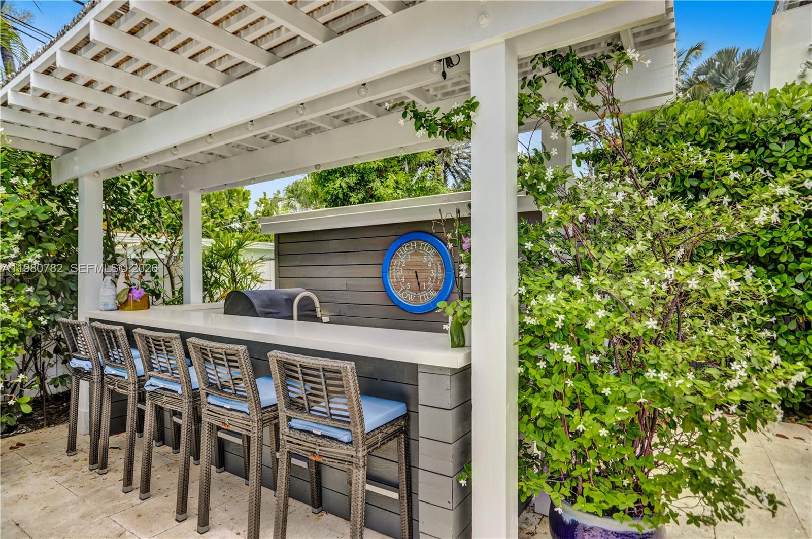 462 Glenridge Road Key Biscayne, FL 33149 - Photo 26 of 32 a table with a vase of flowers sitting on a table and chair