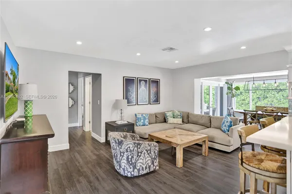 a living room with furniture and a wooden floor