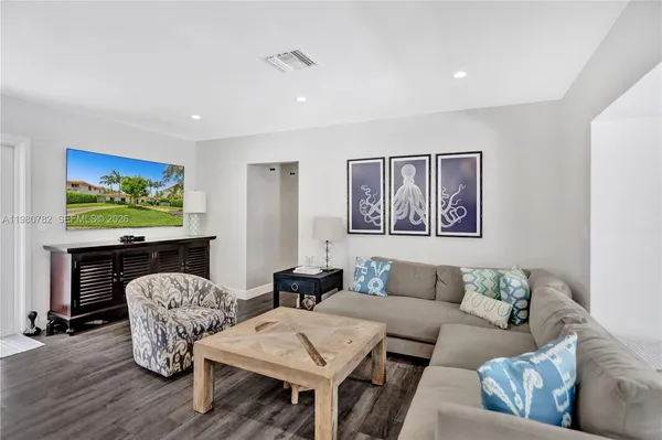 a living room with furniture and wooden floor