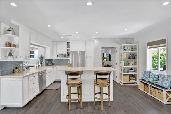 a kitchen with stainless steel appliances kitchen island granite countertop a wooden cabinets and island
