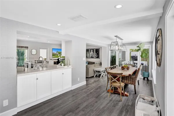a kitchen with stainless steel appliances kitchen island a table and chairs in it