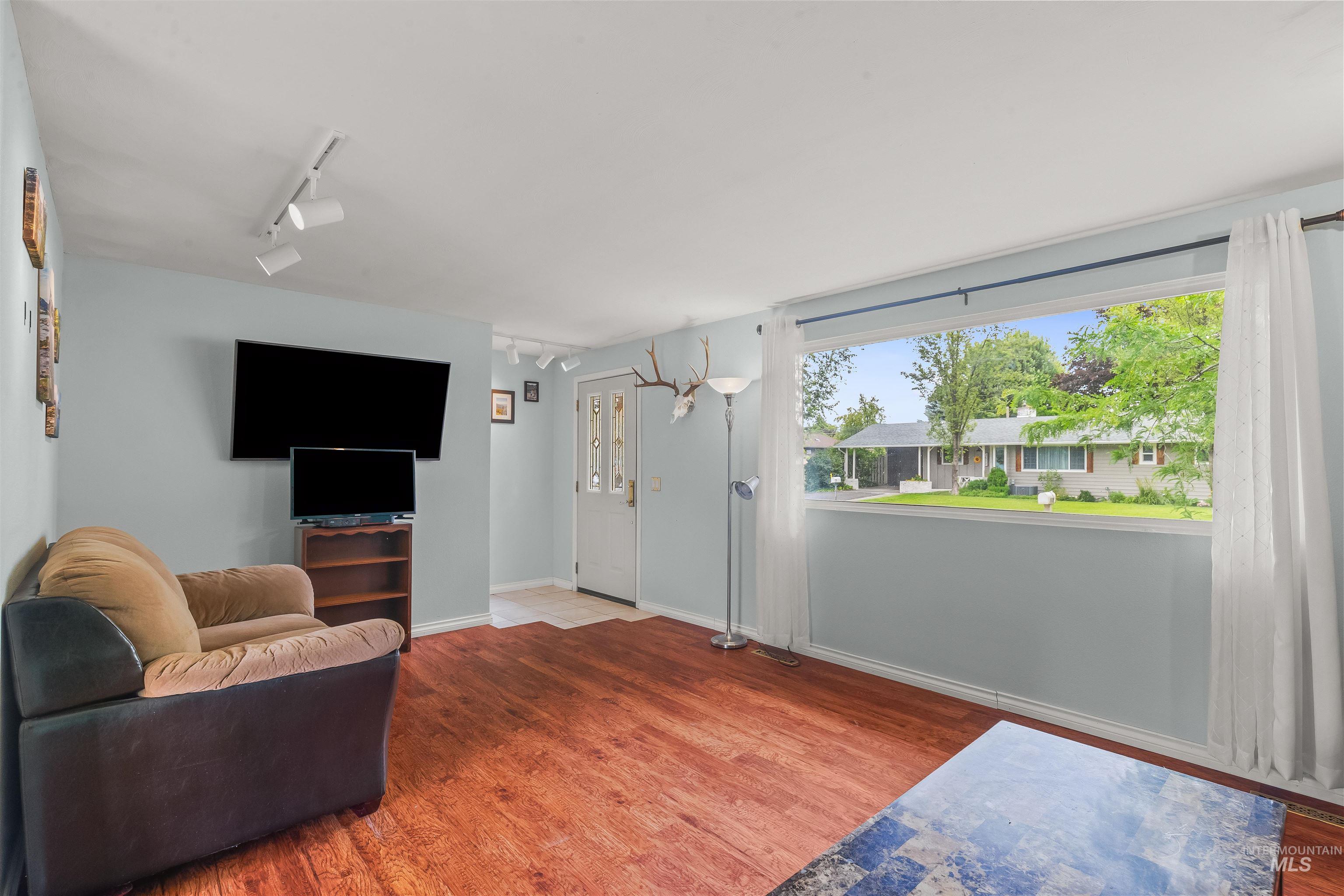 3620 18th Street Lewiston, ID 83501 - Photo 11 of 32 Living area featuring wood-finish flooring, light blue wall paint, and overhead track lighting