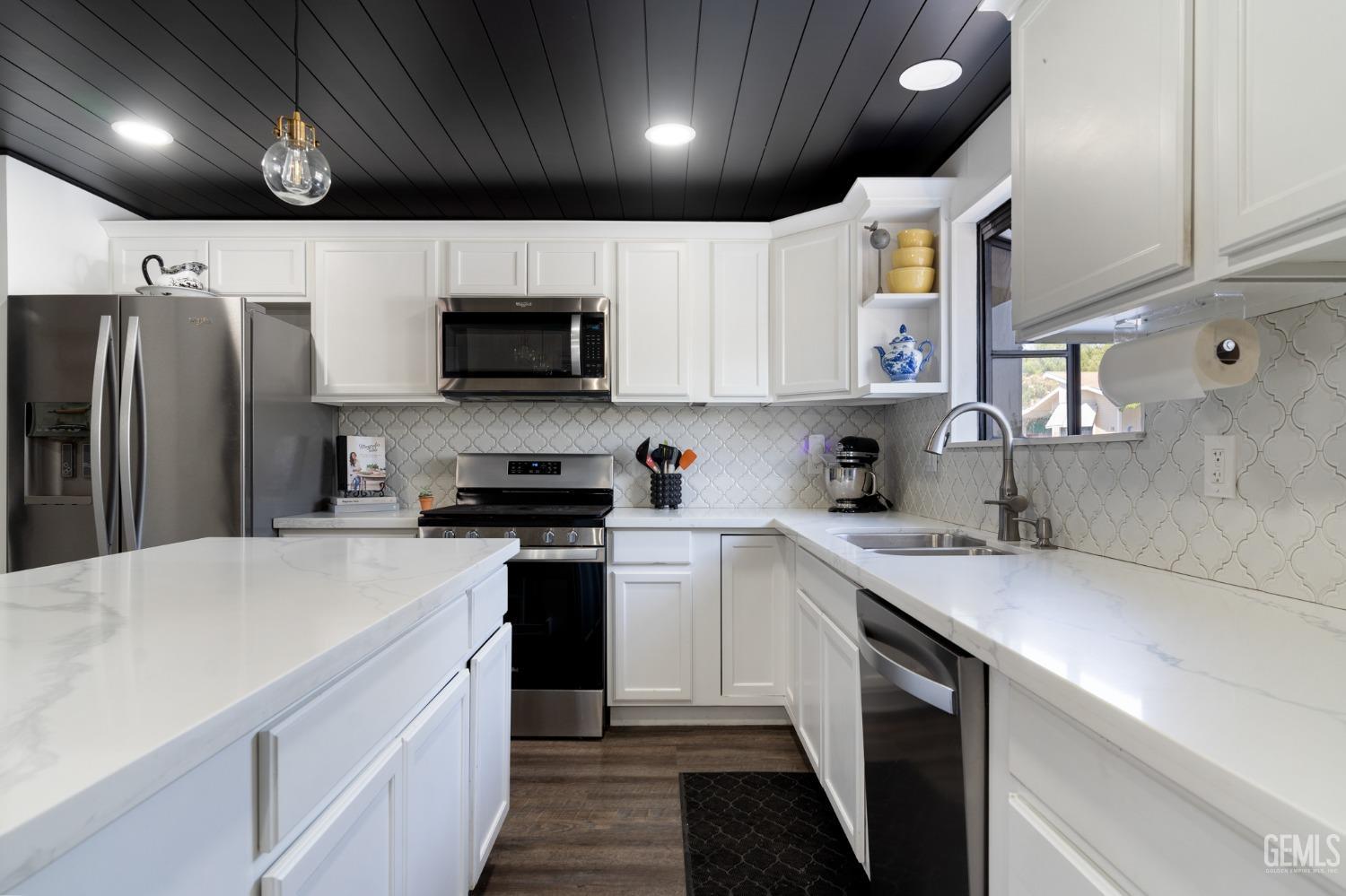 Undisclosed Address Bakersfield, CA 93306 - Photo 12 of 27 a kitchen with a sink a refrigerator and a stove top oven