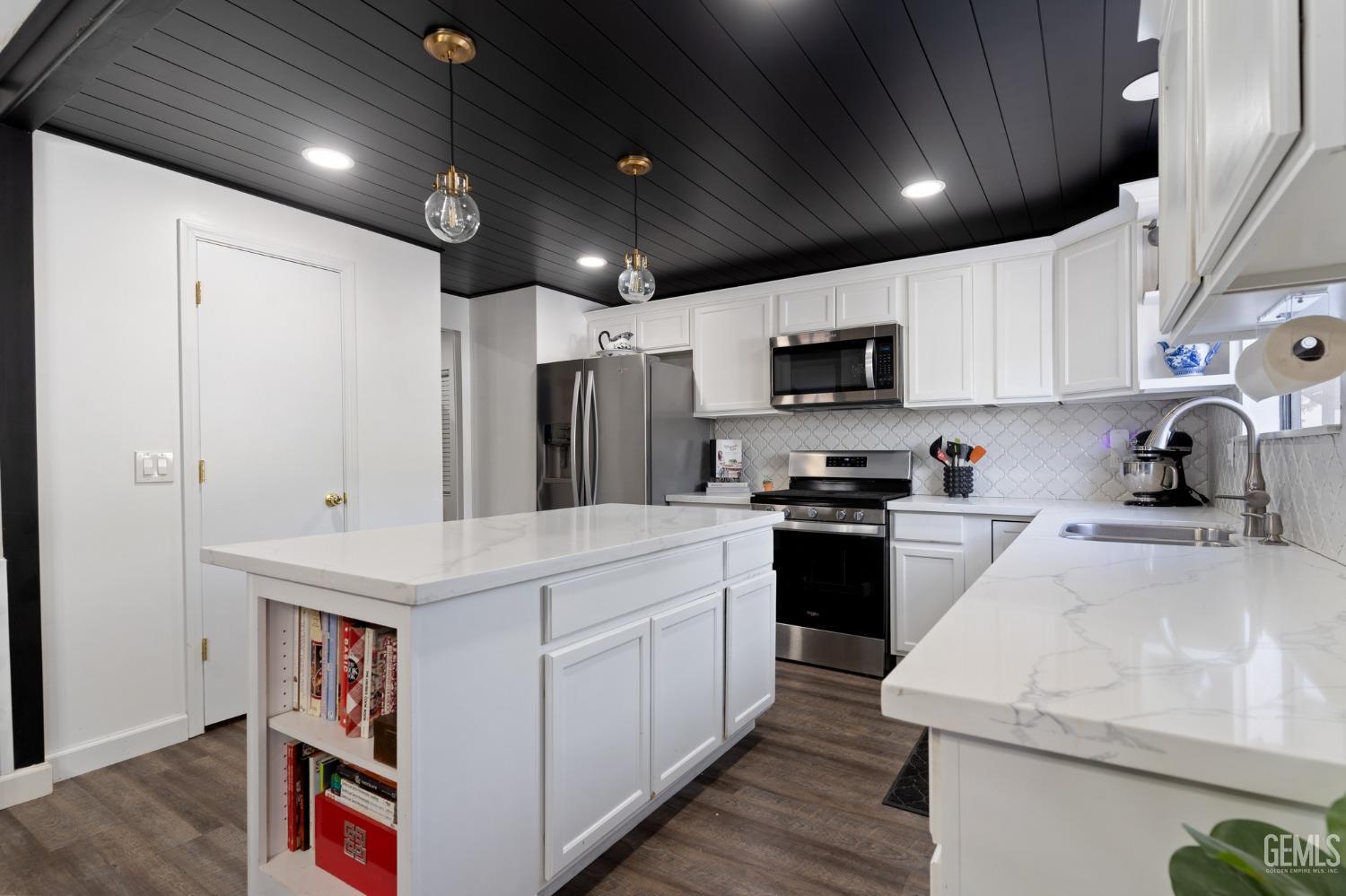Undisclosed Address Bakersfield, CA 93306 - Photo 20 of 27 a kitchen that has a lot of cabinets and wooden floor