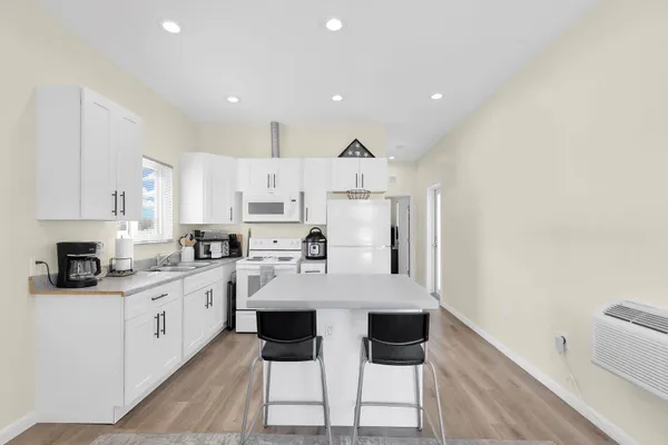 a kitchen with white cabinets and white appliances