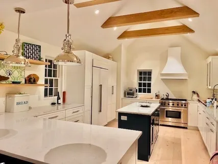 a kitchen with stainless steel appliances kitchen island granite countertop a stove a sink and a refrigerator