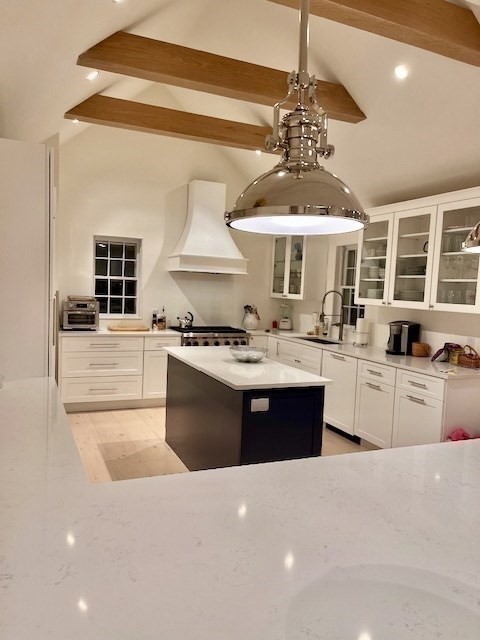 76 Orange Street Nantucket, MA 02554 - Photo 8 of 34 a large kitchen with stainless steel appliances a large counter top a stove and a chandelier