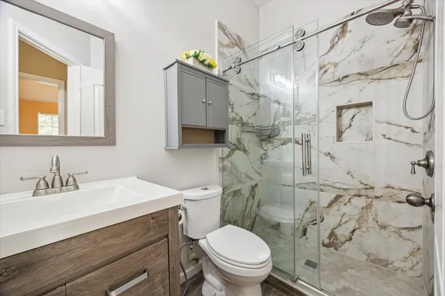 a bathroom with a sink a toilet and shower