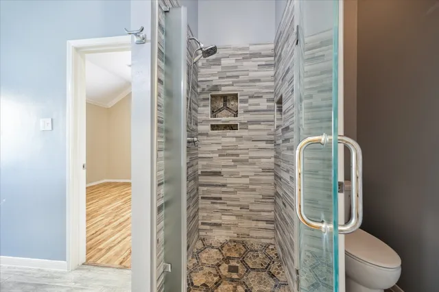 a bathroom with a toilet and a shower