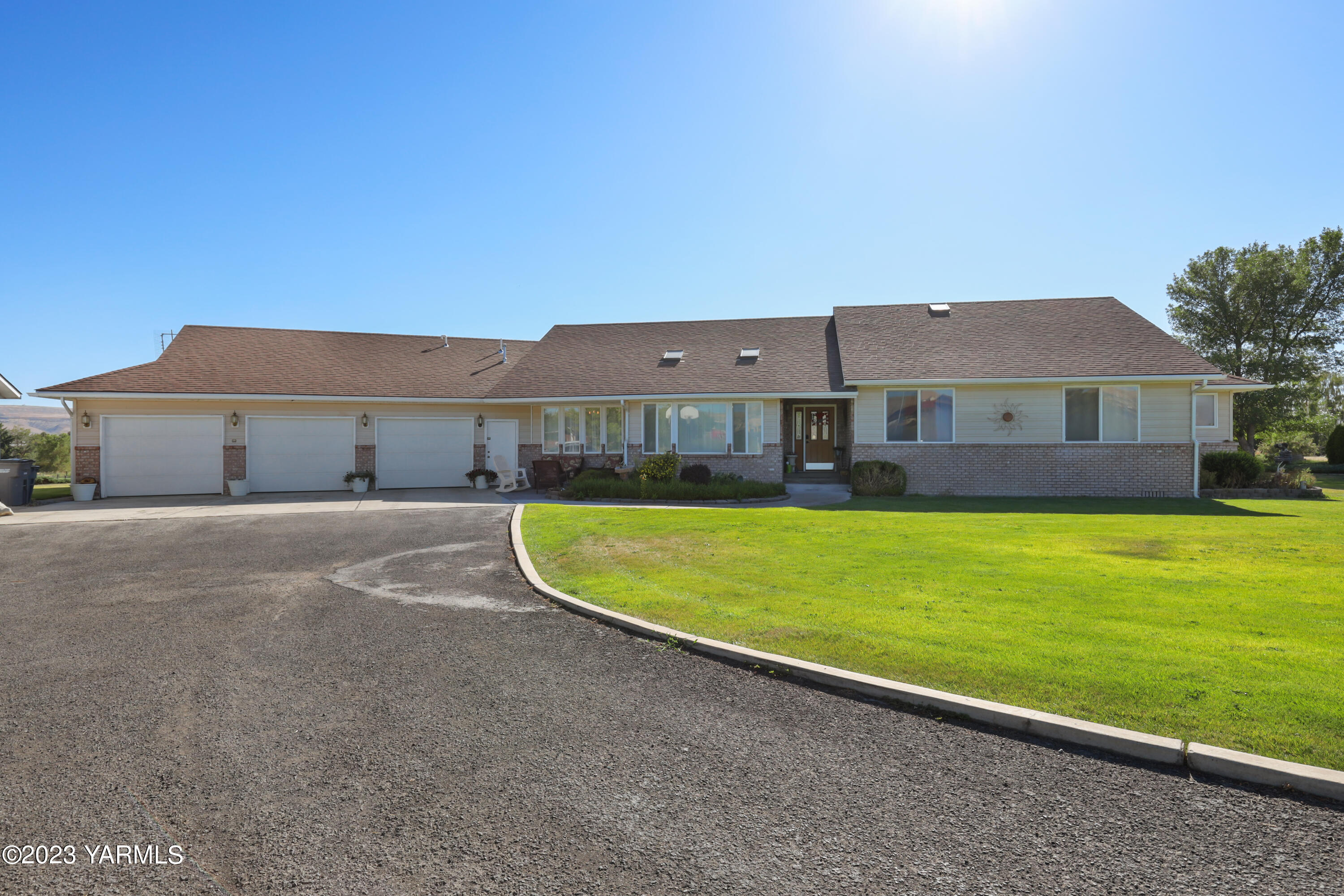 a view of a large pool with lawn chairs under an umbrella