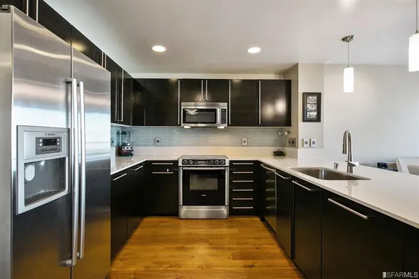 a kitchen with stainless steel appliances granite countertop a sink stove and refrigerator