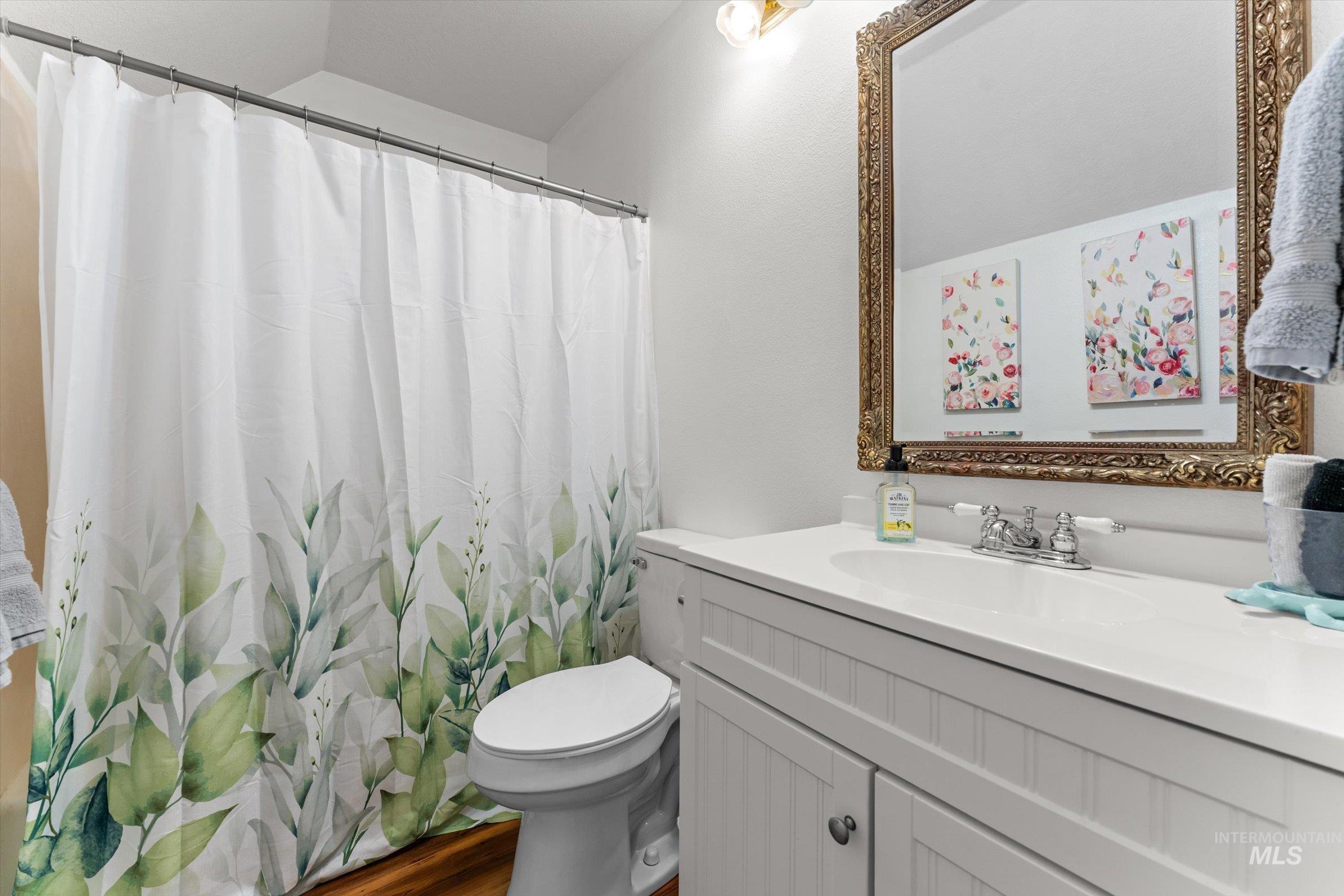 315 South Middlefork Road Garden Valley, ID 83622 - Photo 22 of 49 Full bathroom with vanity, dark wood-style floors, and curtained shower