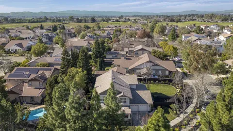 a view of a house with a yard and chairs