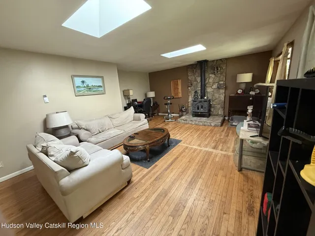 a living room with furniture a lamp wooden floor and a rug