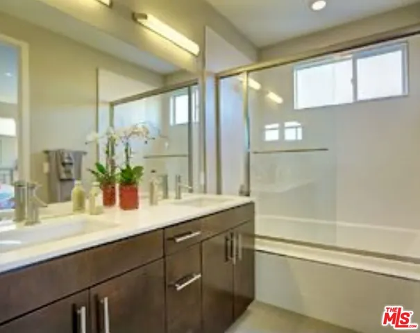 a bathroom with a granite countertop sink mirror and a bathtub