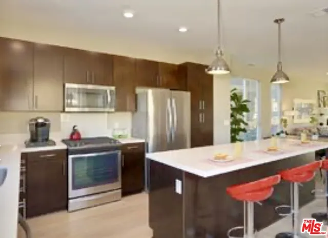 a kitchen with kitchen island a counter top space appliances and cabinets