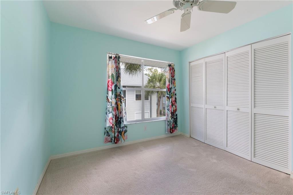 1915 Courtyard Way, Unit G202 Naples, FL 34112 - Photo 17 of 22 Unfurnished bedroom featuring light colored carpet, ceiling fan, and a closet