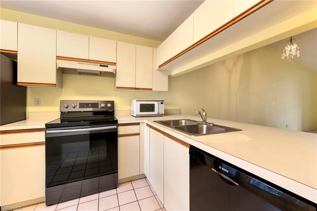 1915 Courtyard Way, Unit G202 Naples, FL 34112 - Photo 3 of 22 Kitchen featuring stainless steel electric stove, dishwasher, light countertops, and white microwave