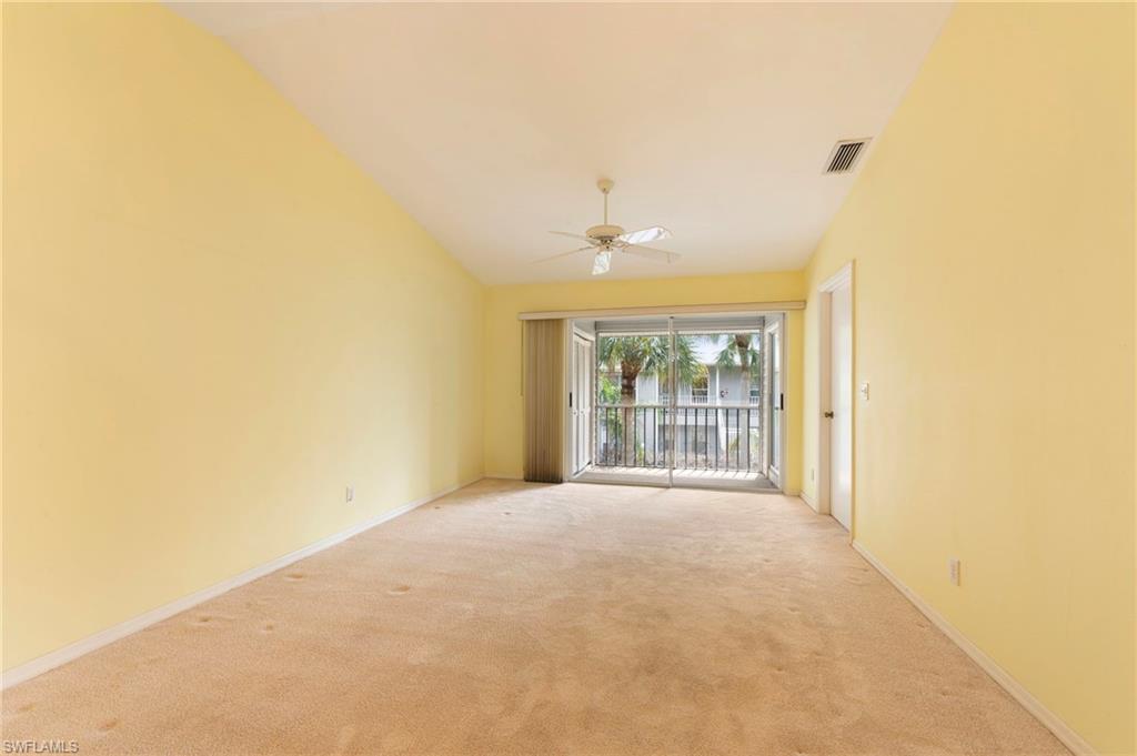 1915 Courtyard Way, Unit G202 Naples, FL 34112 - Photo 7 of 22 Empty room with a ceiling fan, vaulted ceiling, and light carpet