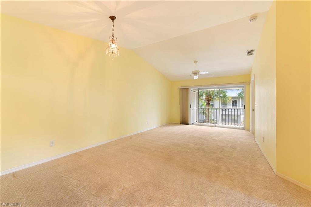1915 Courtyard Way, Unit G202 Naples, FL 34112 - Photo 8 of 22 Unfurnished dining and living room, featuring light carpet, vaulted ceiling, suspended lighting, and ceiling fan