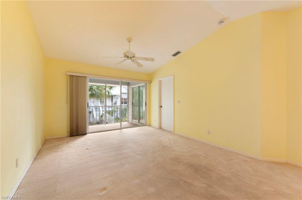 1915 Courtyard Way, Unit G202 Naples, FL 34112 - Photo 9 of 22 Empty room featuring lofted ceiling, ceiling fan, and light carpet