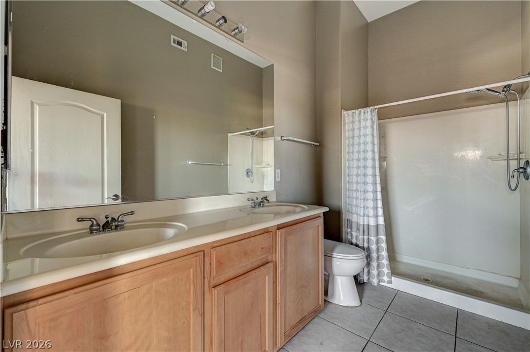 8985 South Durango Drive, Unit 2187 Las Vegas, NV 89113 - Photo 32 of 73 Double vanity and a spacious walk-in shower elevate this practical bathroom.