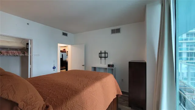 a bed sitting in a bedroom next to a window